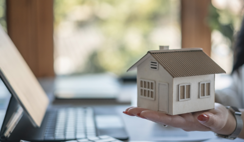 Decoratieve afbeelding houten huisje vastgehouden