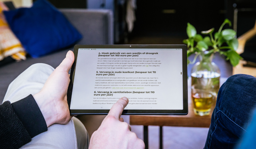 Persoon met tablet in de hand die informatie over isoleren opzoekt. 