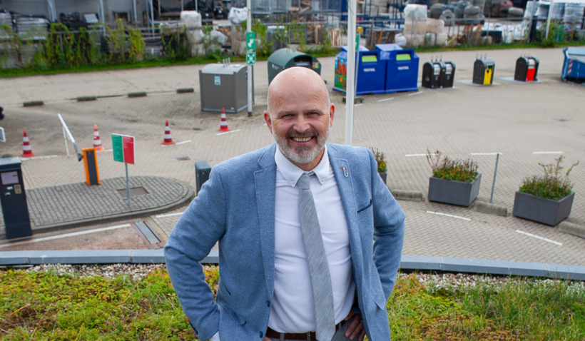 Wethouder Jan Kramer staat op het groene dak van de Milieustraat van gemeente Leusden.