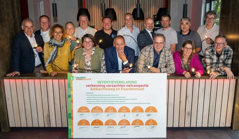 Ondernemers, bedrijvenkring Leusden en de gemeente ondertekenen intentieverklaring. Het lichtsnoer op de foto verbindt de betrokken partijen, net als het netcongestieprobleem.