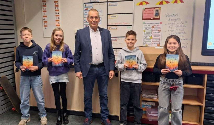 Kinderen uit groep 7A van ’t Palet nemen het boek in ontvangst van wethouder Frank de Wit.
