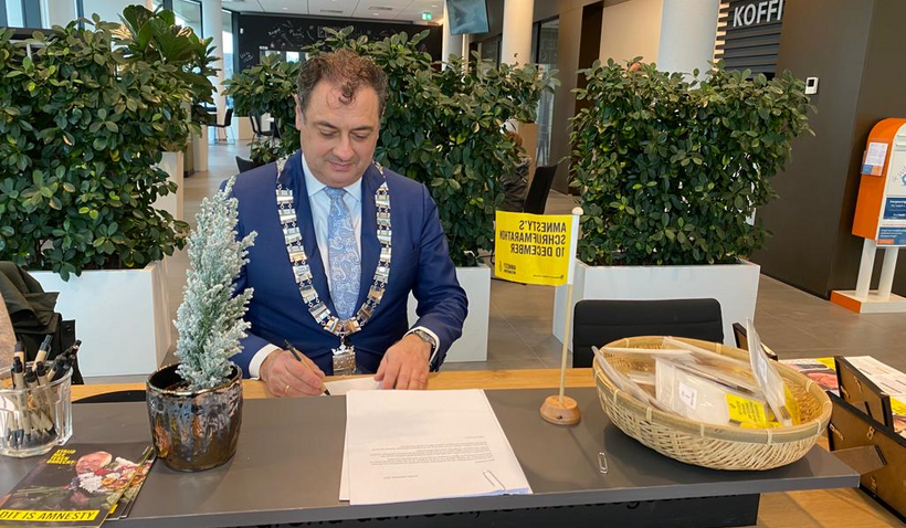 Burgemeester Gerolf Bouwmeester ondertekent brieven voor schrijfmarathon Amnesty Leusden
